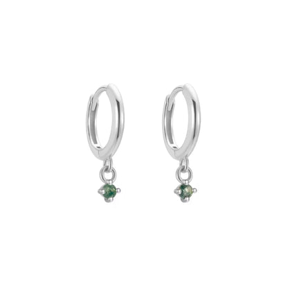 Silver hoop earrings with green gemstones on a white background